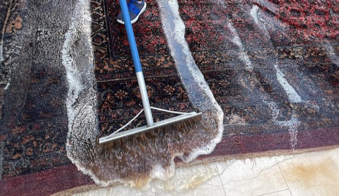  a rug undergoing a rinsing process