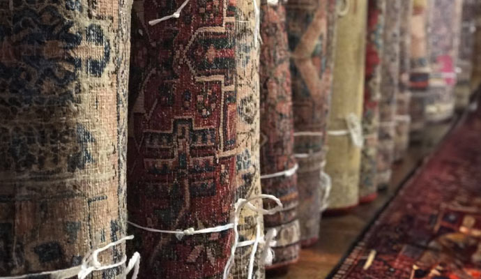 Different types of rolled rugs are stored in the rug storage.