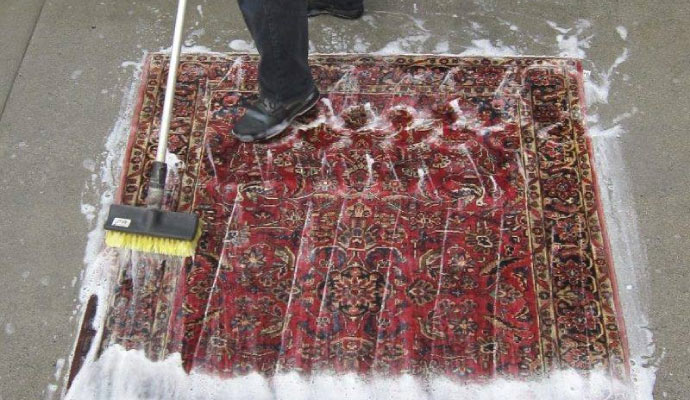 rug cleaning with a  scrubbing brush that has yellow bristles 