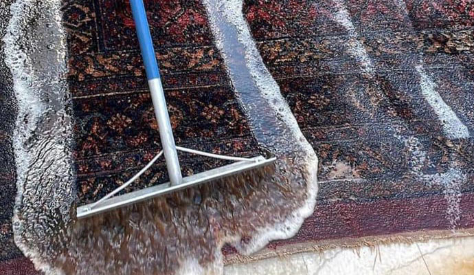  a rug undergoing a rinsing process